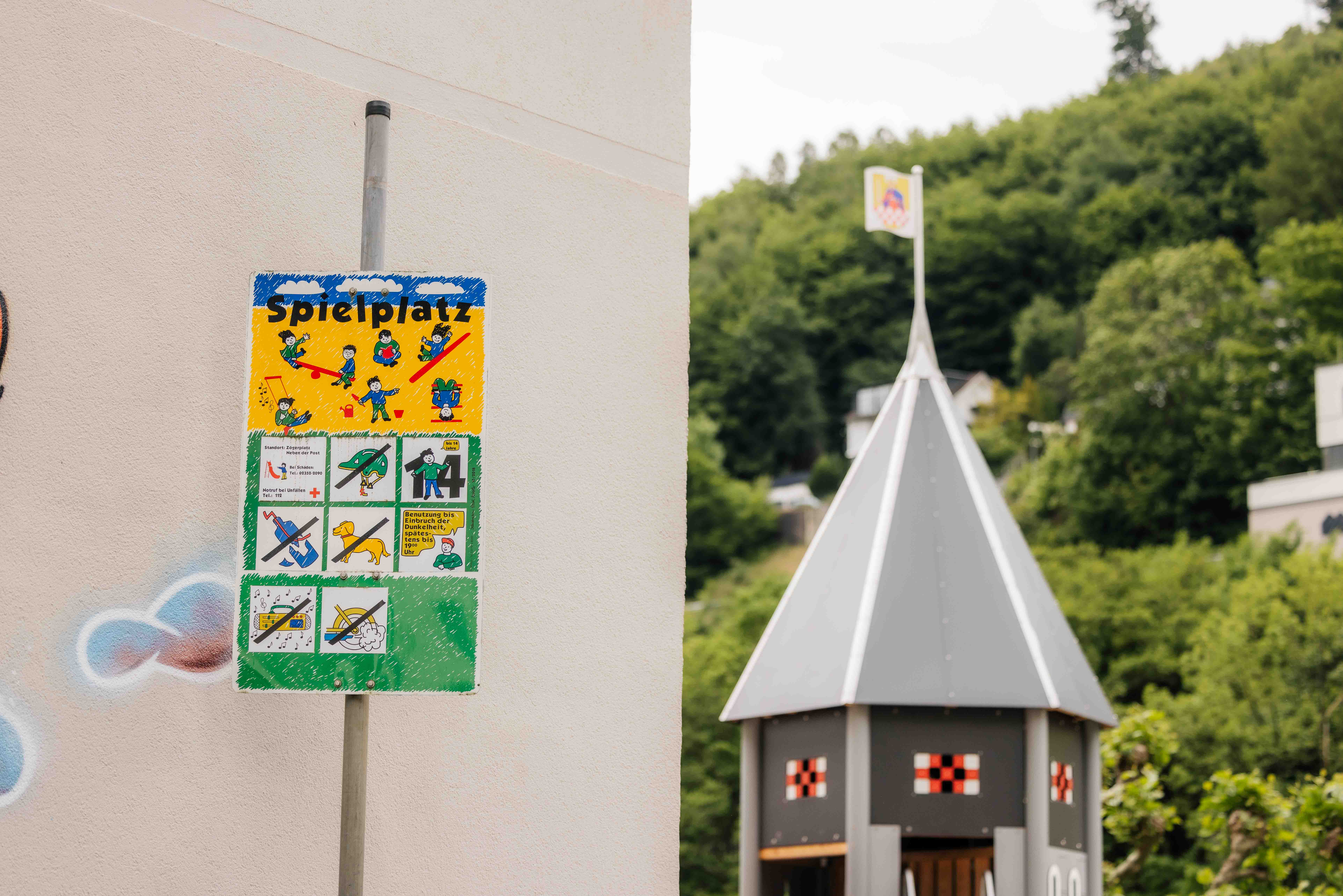 Das Bild zeigt einen Spielplatz in Altena City und Fokussiert das Schild mit den Regeln für die Benutzung